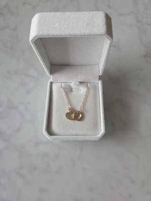 Halsband med hjärtan - Snyggt halsband med två ett är dekorerat med små glittrande stenar och det andra är slätt och blankt.