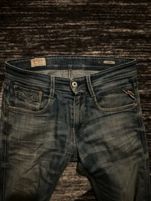 Replay Anbass jeans blå slim fit - Snygga blå Replay Anbass jeans i slim fit med klassisk femficksdesign och diskreta slitningar🙌💯 Jeansen har normal midja, raka ben och är tillverkade i mjukt jeansmaterial med stretch för extra komfort. Perfekt för dig som gillar stilrena och moderna jeans. Väldigt feta💯👌 st 29/32😉