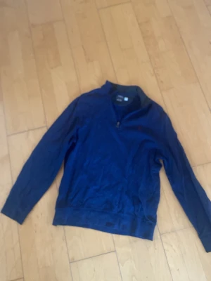 Blå half zip tröja från Polo Ralph Lauren - Säljer en mörkblå långärmad tröja från Polo Ralph Lauren i storlek M. Tröjan har en half zip-dragkedja vid halsen och det klassiska broderade Polo-logot på bröstet. Materialet är mjukt och känns som bomull, perfekt för höst och vinter.