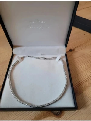 Halsband Vidal & Vidal - Bilderna visar ett smycke, specifikt ett halsband från Vidal & Vidal Signature Collection, med tillhörande certifikat och kvitto. Ingen väst syns på bilderna.