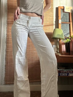 Vita lågmidjade cargopants - Dröm till linnebyxor!! Vita med 2000’s detaljer med fickor både fram och bak, jag är 170 och de lägger sig perfekt över skorna🌞står att det är en bomull och linnemix 