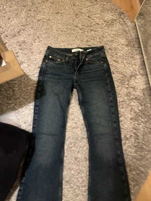Bootcut jeans  - Säljer ett par mörkblå jeans från Junkyard med detaljer på bakfickan, helt oanvända men utan prislapp
