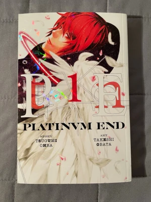 Platinum End vol 1  - Platinum End är en spännande manga med mörka och övernaturliga teman, skapad av teamet bakom Death Note. Perfekt för dig som gillar intensiva berättelser, coola karaktärer och episka strider om ödet. Boken har snyggt omslag och är ett måste för manga-fans!