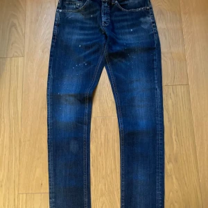 Blå Dundop jeans, storlek 32 - Snygga blå jeans från Replay i modell med smal passform. Jeansen har coola slitningar, diskreta färgstänk och klassiska bakfickor med gul söm. Materialet är jeans med en skön känsla och detaljer som sticker ut. Perfekta för dig som gillar en modern look.