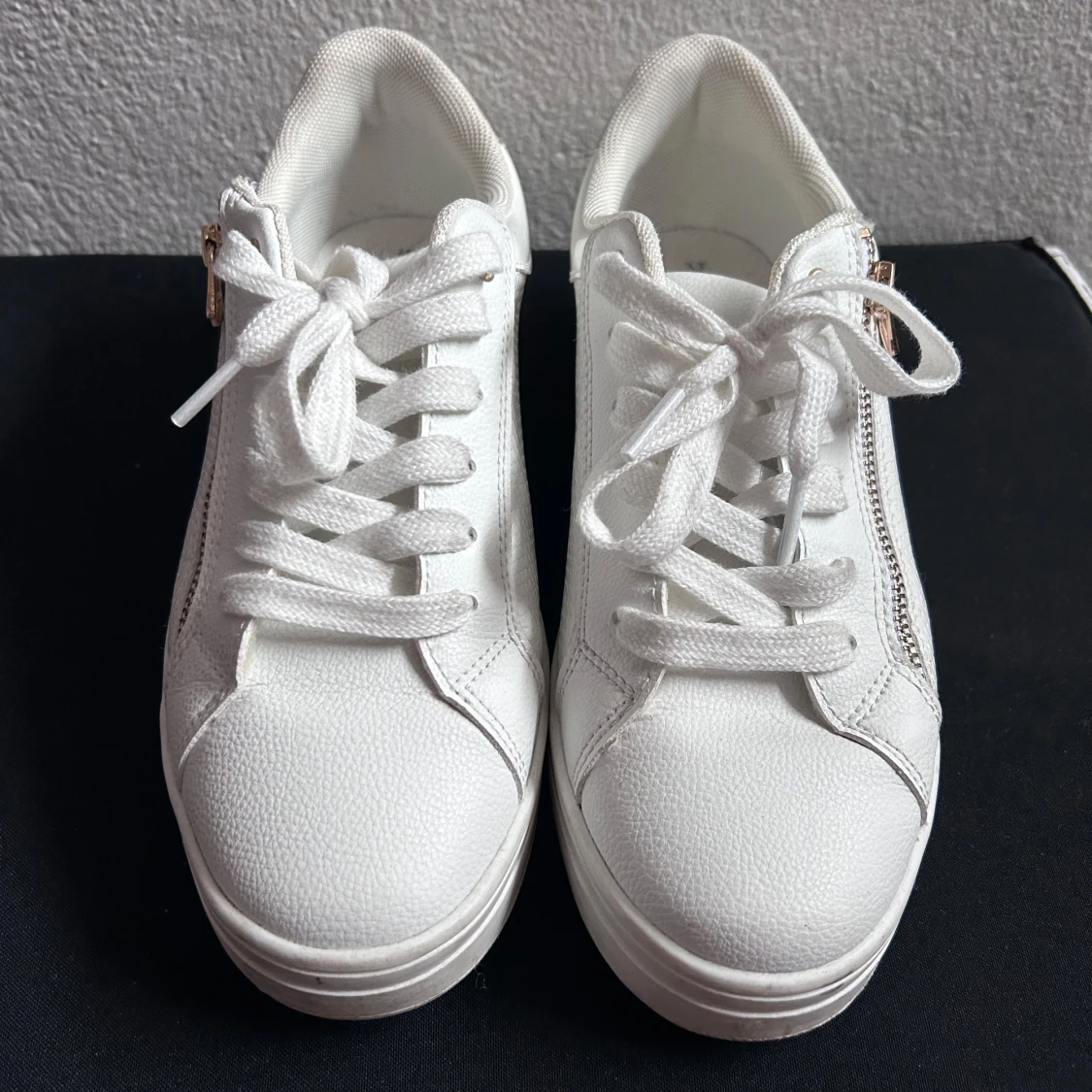 Vita sneakers med gulddetalj och dragkedja