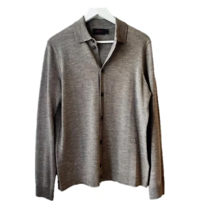 Beige merinoullsskjorta från Morris - Säljer en stilren beige skjorta från Morris i 100% merinoull. Skjortan har klassisk krage, knäppning framtill och långa ärmar. Perfekt för dig som gillar en clean och tidlös look med premiumkänsla.