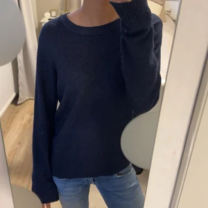 Mörkblå stickad tröja med rund hals - Enkel och stilren mörkblå stickad tröja med rund halsringning och långa ärmar. 