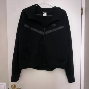 Svart nike tech byxor och hoddie  - Svart Nike tech från stadium för dam. Jätte fint knappt använt nästan som ny. Säljer eftersom att den inte kommer till användning. Säljer både tröjan och byxorna tillsmans. Jätte skönt material också. Stlk S