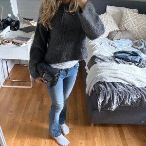 Blå bootcut jeans med låg midja - Snygga blå jeans med lätt slitning och bootcut-ben. Jeansen har låg midja och klassisk femficksdesign. Perfekta för dig som gillar en avslappnad men ändå trendig look. Materialet är jeans och passformen är normal.