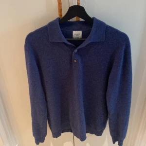 Blå kashmirpiké från John Henric - Blå pikétröja i 100% kashmir från John Henric. Tröjan har klassisk krage, tre knappar framtill och långa ärmar. Perfekt för dig som vill ha en stilren och lyxig look med mjuk känsla. Inga defekter med tröjan, 9/10 skick. Nypris 2799, kan ändra mitt pris vid snabb försäljning.