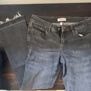 Grå jeans från John Baner med frans - Snygga grå jeans från John Baner med klassisk femficksdesign och fransade benslut. Jeansen är utsvängda och är tillverkade i mjukt denimtyg. Perfekta för en avslappnad och trendig look.