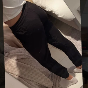 Svarta mjukisbyxor från Lindex - Svarta linnebyxor från Lindex i modellen AVA. Byxorna har resår i midjan med snörning och är tillverkade i ett mjukt material. De har en avslappnad passform och raka ben, perfekta för chill dagar hemma eller när du vill vara bekväm.