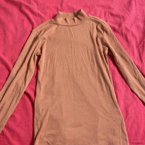 Beige turtleneck tröja. - En beige turtleneck tröja, perfekt för hösten.