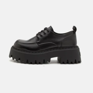 Svarta buffalo snörpumps - Säljer ett par svarta chunky skor med grov plattformssula och snörning. Skorna har rund tå och är tillverkade i blankt syntetmaterial som ger en cool och edgy look. Perfekta för dig som vill sticka ut med din stil.