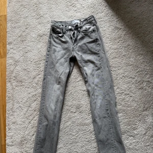 Grå jeans från Zara, raka ben - Säljer ett par grå jeans från Zara med raka ben och klassisk femficksdesign. Jeansen har normal passform och är tillverkade i bomull. Perfekta för dig som gillar en enkel och stilren look.