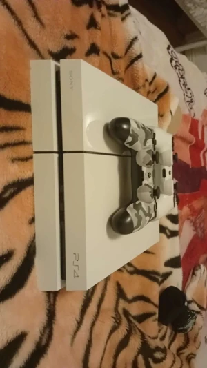 PlayStation 4 Glacier White - Snygg PlayStation 4 Glacier White med kamouflagekontroll och tillhörande kablar. Konsolen och kontrollen ser ut att vara i gott skick utan synliga repor eller skador. Perfekt för dig som vill spela populära PS4-spel direkt! Strömkabel och HDMI medföljer.Det enda som inte fungerar är skivläsaren.