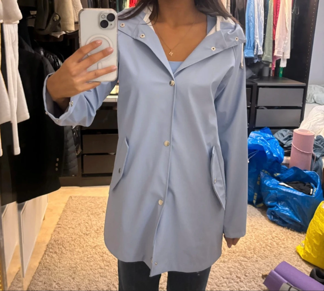 Ljusblå regnjacka med huva