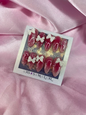 Mochi Blush (S);Medium Almond - Set med handgjorda press-on naglar i en medium mandelform,  i rosa med kroeansk blush effekt och glittig cateye och dekorerade med vita 3D-rosetter och små kristaller. Naglarna har en glossy finish och finns i S: 15 mm, 11,5 mm, 12 mm, 11 mm, 9 mm . Perfekt för dig som vill ha en söt och girly look.