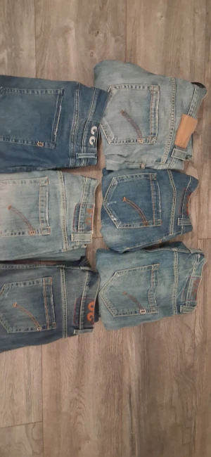 Jeans dondup 5 par jeans - Säljer flera par dondup jeqns ii olika blå tvättar. Klassisk femficksmodell med Replay-logga på bakfickan och kontrastsömmar. Jeansens passform är rak och de har detaljer som bälteshällor och knappstängning. Perfekt för dig som gillar streetwear och snygga denimlooks.