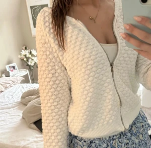 Vit kofta med dragkedja - Säljer en vit kofta med dragkedja och coolt bubbligt strukturmönster. Koftan har långärmad passform och ribbade muddar vid ärmslut och nederkant. Man kan få den för lite billigare vid snabb affär 