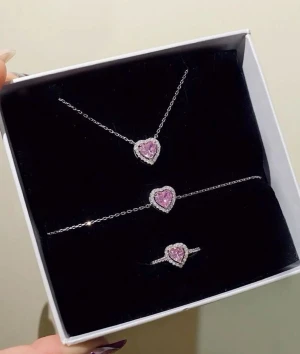 Smyckeset med hjärtan i silver och rosa pandora - Snyggt smyckeset med halsband, armband och ring i silverfärg. Alla delar har ett hjärtformat hänge med rosa stenar omgivna av glittrande vita stenar. Perfekt för dig som gillar söta detaljer och vill sticka ut lite extra.