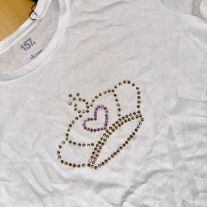 Vit t-shirt Lager 157  - Säljer en vit t-shirt från 157 med ett glittrigt motiv. T- shirten har rund hals och korta ärmar. Tröjan är i grund från lager 157, tröjan går att tvätta OBS!! Bara i 30 grader, ingen torktumling 