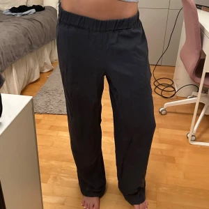 Mörkblå loose byxor med resår - Snygga mörkblå byxor med loose passform och bred resår i midjan. Byxorna har raka ben och en enkel bakficka. Perfekta för chill dagar och sköna att bära tack vare det mjuka materialet.