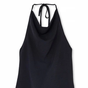 Svart halterneck topp med öppen rygg - Säljer en svart halterneck topp med snygg draperad halsringning och öppen rygg. Toppen har knyt både i nacken och ryggen för en justerbar passform. Aldrig använd (prislapp kvar), från NA-KD storlek 40🪩