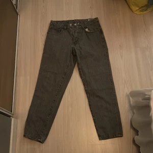 Grå jeansbyxor från Vailent S - Säljer ett par grå jeansbyxor från Vailent i storlek S. Byxorna har klassisk femficksdesign, rak passform och knappstängning framtill. Materialet är robust denim och färgen är mörkgrå med lätt tvättad look. Perfekt för dig som gillar enkel och stilren streetstil.