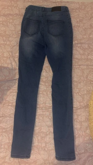 Mörkblå skinny jeans - Snygga mörkblå skinny jeans med klassisk femficksdesign och knappstängning. Jeansen har en smal passform och är tillverkade i stretchigt denim för extra komfort. Perfekt för dig som gillar en stilren och enkel look. Använt nån gång för att testa bara men inget för mig. Skulle säga att de passar som S då dom är väldigt tighta.