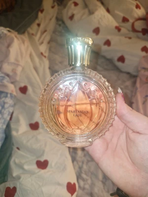 Spartanian Lady Eau de Parfum - Upptäck Spartanian Lady från Laurent Parfum – en unik flaska med modern vibe. Perfekt för dig som vill sticka ut och addera lite lyx till din samling. Flaskan har en cool design och passar dig som gillar att testa nya dofter. Jag säljer den för jag tycker den doftar lite tant 