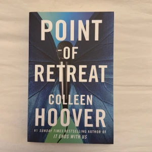 Point of Retreat - En bok av Colleen Hoover, författaren bakom succén 'It Ends With Us'. Omslaget har en mikrofon och fjärilsvingar i blått, vilket ger en modern och kreativ känsla. Perfekt för unga vuxna som gillar starka berättelser och känslor.
