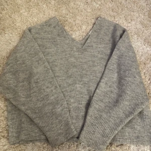 Grå stickad tröja - Grå stickad tröja med v-ringad hals och långa ärmar. 🩷