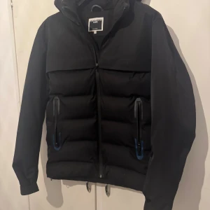 Svart pufferjacka från Jack & Jones - Svart pufferjacka från Jack & Jones i storlek S Knappast använd och är i nytt skick. En enkel och clean jacka för vintern.