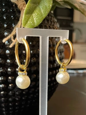 Stainless Steel,Guldiga örhängen med pärlor, NYTT  - Snygga örhängen i guldfärgad stål med rund pärldroppe och små glittriga stenar ovanför pärlan. Perfekt accessoar för att lyfta din outfit med en elegant touch. Klassisk design som passar till många stilar.