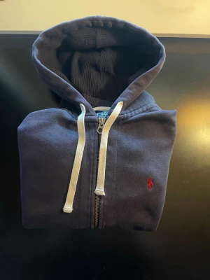 Ralph Lauren Marinblå Zip Hoodie - En Marinblå Ralph Lauren zip hoodie. Nypris ligger 2300kr. Knappast använd
