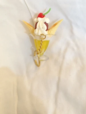 Nyckelring sundae  - Bilderna visar en nyckelring formad som en glassdessert med banan, grädde, körsbär och glasskula. 