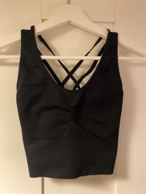 Svart sportbh - Svart sport-bh i en längre modell. Kan användas som tråningslinne också. Perfekt till gymmet! Låg-medium support. Kommer inte ihåg vilket märke men tror den är köpt på stadium eller Intersport. Den är i bra skick och inte synligt använd. 🫶🏼