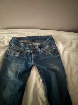 Blå low waist flare jeans Y2K / 00s - Blå low waist jeans med flare/bootcut-passform. Tajta upptill och utsvängda nertill – klassisk Y2K/00-tals stil. I mycket bra skick, inga hål eller fläckar. Perfekta vardagsjeans som funkar både uppklätt och casual. 🔹 Stil: Y2K / 00s 🔹 Midja: Low waist 🔹 Passform: Flare / bootcut 🔹 Färg: Blå Prutbart – vill bli av med dem snabbt 💙 