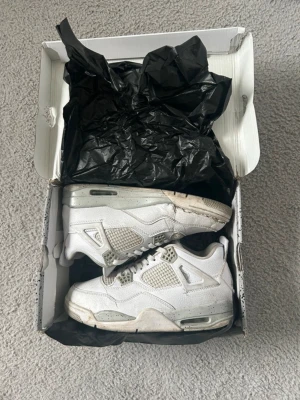 Nike Air Jordan 4 Retro vit - Ett par Air Jordan 4 retro i storlek 4. Skorna är använda och har tydliga skador, bland annat  sprickor i sulan och sönder framtill se bilder.Missfärgning på mellansulan. Men annars så kan man använda skorna. Hör av dig via frågor⁉️