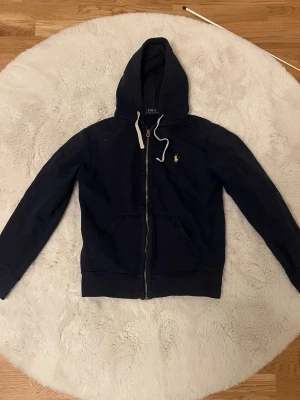 Zip up hoodie från Ralph Lauren Xs - En väldigt fin mörkblå zip up hoodie från Ralph Lauren i storlek xs. Märket är gult. 