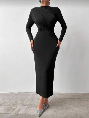 Svart långklänning med lång ärm - Säljer en stilren svart långklänning med lång ärm och figurnära passform. Klänningen har en enkel design med lätt drapering över bröstet och midjan, vilket ger en snygg siluett. Perfekt för dig som gillar minimalistisk och elegant stil.