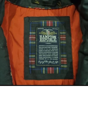 Mörkgrå parkas från Hampton Republic - Säljer en mörkgrå parkas från Hampton Republic med orange foder och huva. Jackan har flera stora fickor med både knappar och dragkedja, samt detaljer som synliga sömmar och ribbade muddar vid ärmsluten. Perfekt för kalla dagar och riktigt snygg streetstil.