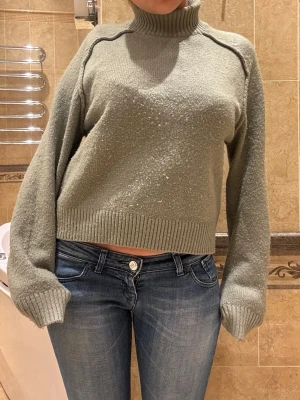 Grön polotröja  - Mysig grå polotröja med ribbad hög krage. Perfekt till vintern och hösten med något kortare passform. Tröjan är något nopprig med går förmodligen att ta bort med en noppringsmaskin❤️