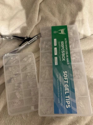 Soft gel nageltippar 600-pack - Säljer ett set med 600 ultrakorta soft gel nageltippar i 12 olika storlekar. Tipparna är klara och kommer i en praktisk plastlåda med fack. Perfekt för dig som vill fixa snygga naglar hemma. Nagelklippare i metall medföljer, den är väldigt seg men fugerar