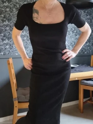 Svart ribbad klänning Karen Millen - Supersnygg svart ribbad klänning från Karen Millen med fyrkantig urringning och korta ärmar. Klänningen har en tight passform och är tillverkad i ett stretchigt material som sitter riktigt snyggt på kroppen. Perfekt för dig som gillar stilrena och trendiga plagg. Använt , har nån noppra men i övrigt jättefint skick! =)