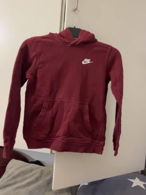 Vinröd hoodie från Nike, strl: 137-147 - Säljer en vinröd långärmad hoodie från Nike 