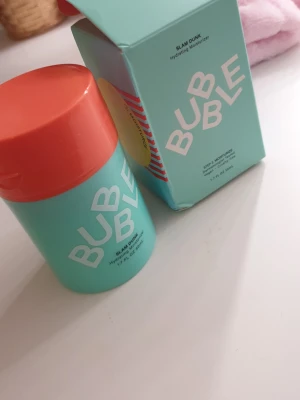 Bubble Slam Dunk Hydrating Moisturizer - Bubble Slam Dunk Hydrating Moisturizer i en snygg turkos och orange plastförpackning med pumpfunktion. Innehåller 50 ml återfuktande ansiktskräm som är vit och krämig i konsistensen. Perfekt för dig som vill ha en fräsch och enkel hudvårdsrutin.