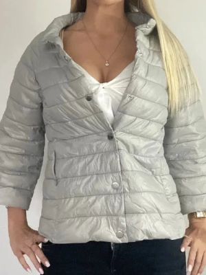 Grå hermo liknande jacka - Säljer en pufferjacka med tre kvarts ärmar i ljusgrå färg. Jackan är i storlek 40 och passar mig bra som vanligtvis har xs/s. Skriv gärna för fler bilder så skickar jag inom kort!! 