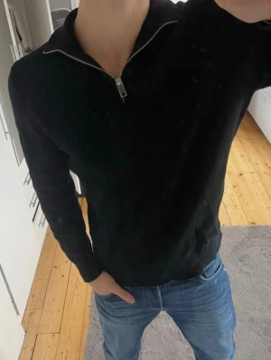 Svart Ribbstickad half zip   - Jag har aldrig använt denna endast testad. Tröjan är storlek M, skulle tro att den även kan passa L och är Ribbstickad. Originalpris är 399. Tröjan är från HM, Vid fler frågor hör av dig !